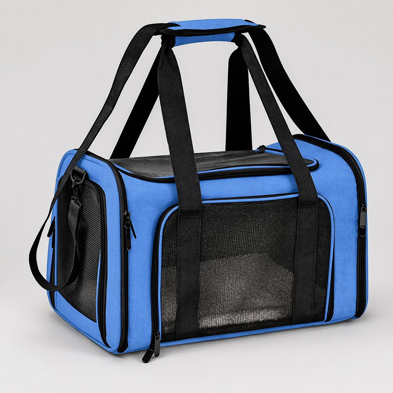Blue soft-sided pet carrier bag with mesh panels and black carry handles on a light gray background